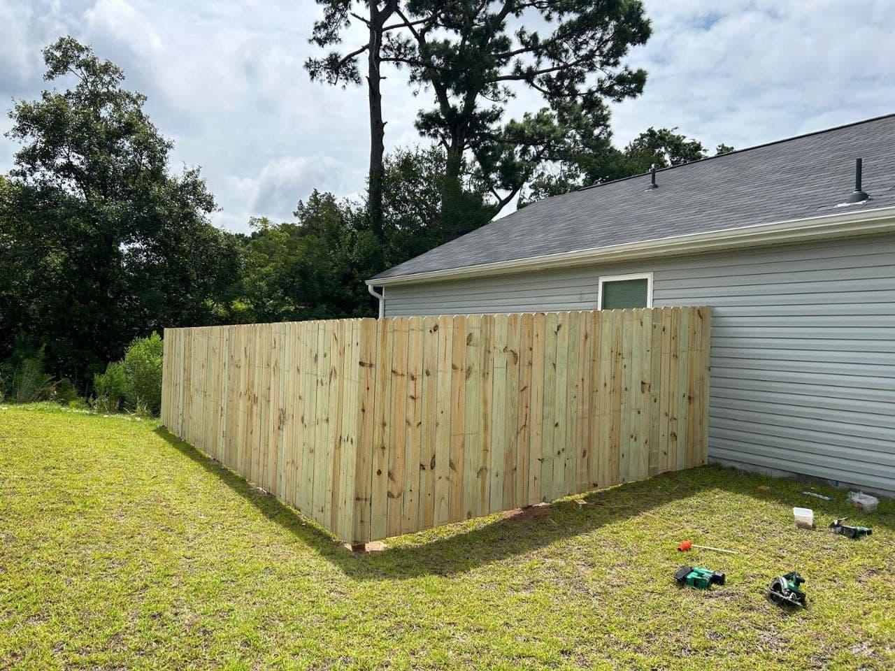 Finished wooden privacy fence at house corner